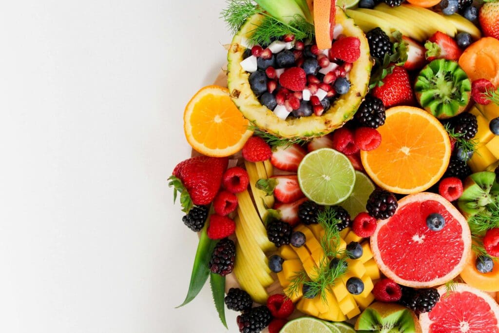 Variedad de frutas frescas como naranjas, fresas, moras y kiwi, ideales para mejorar la digestión de manera natural.