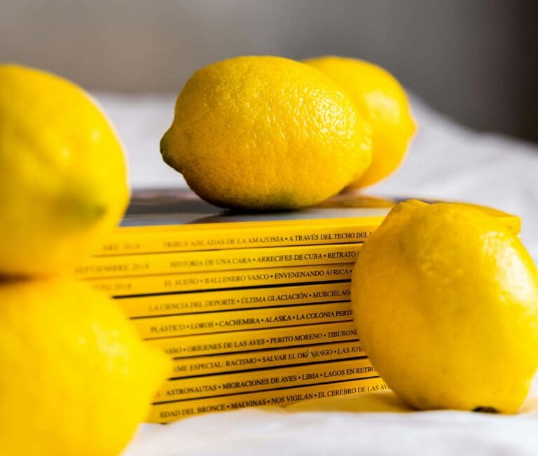 Limones frescos sobre revistas, simbolizando la filosofía de nutrición saludable de la dietista-nutricionista Carmen Martín.